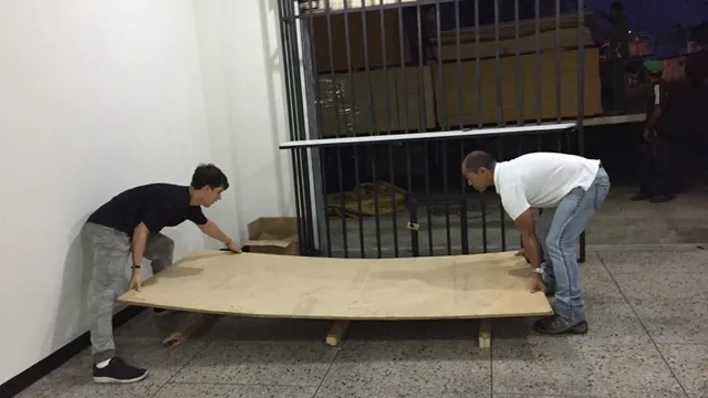 Dos miembros del equipo cargando un tablero en la tienda